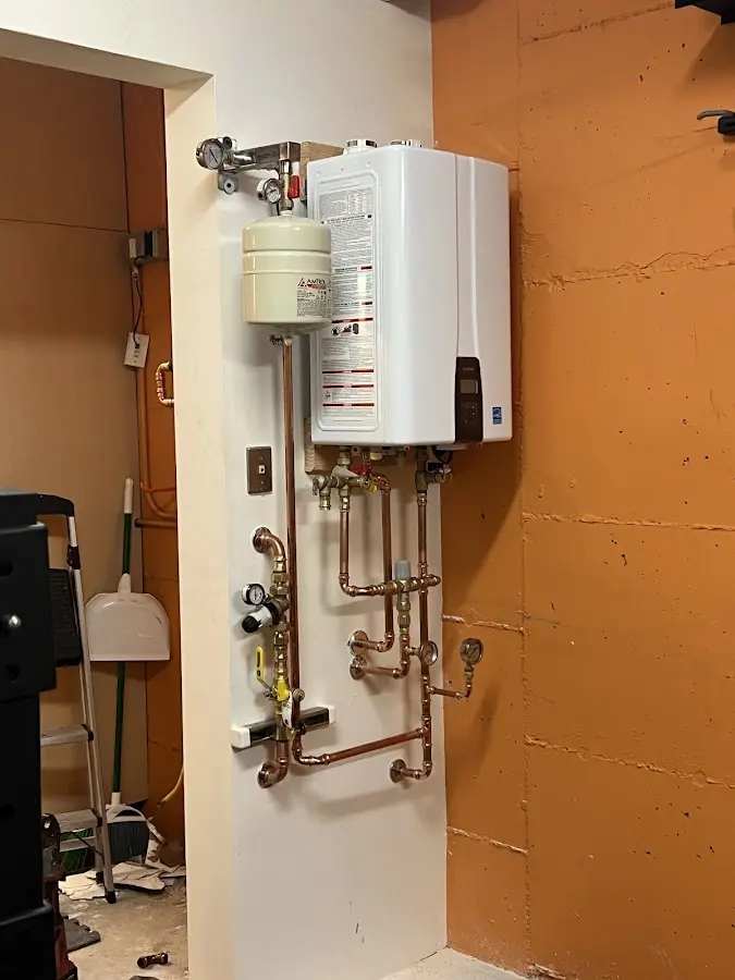 Plumbing technician inspecting water heater connections in Bremen